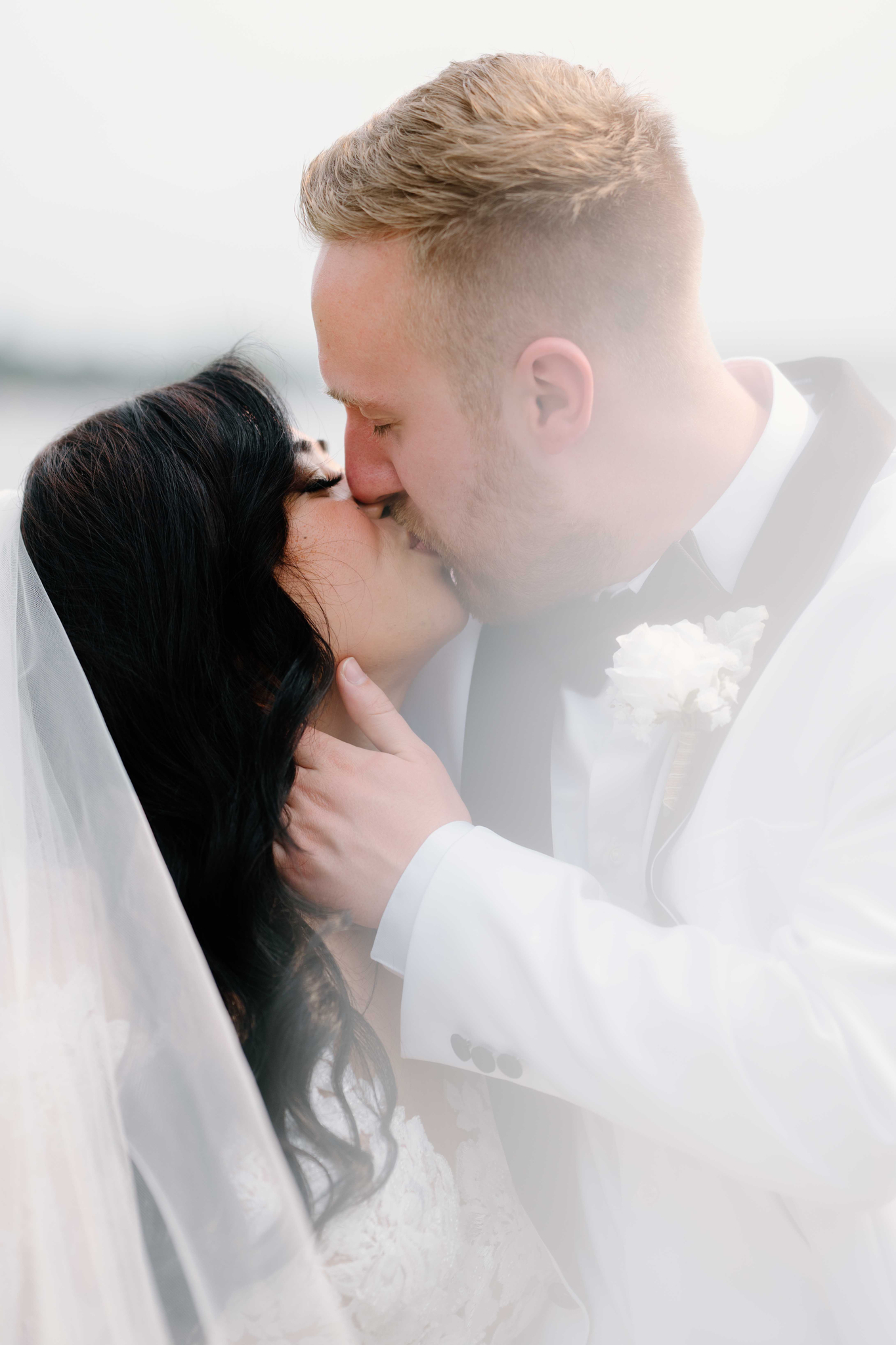 Newlyweddings kissing with veil swooped into the camera